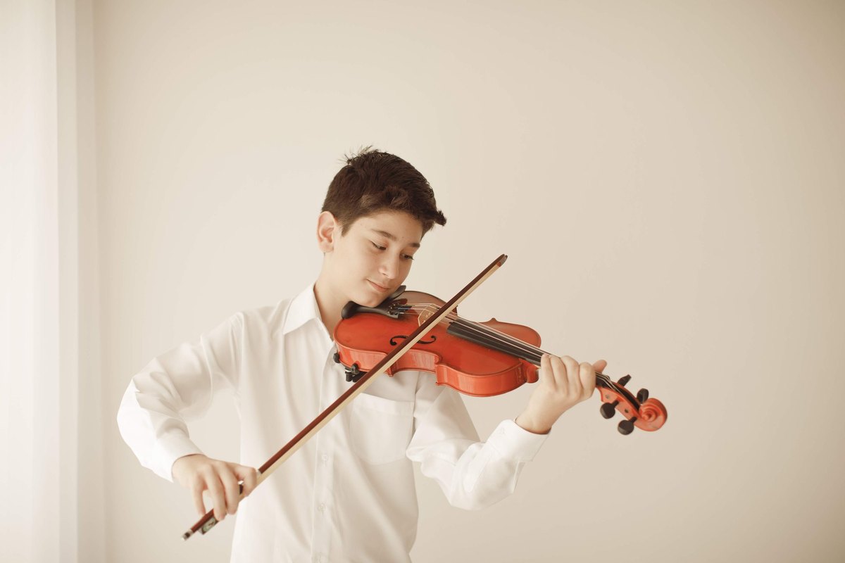 Aluno bolsista do Musicarium tocando violino.